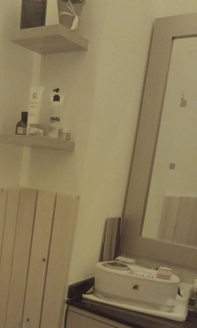 La cabine beauté — Lambris de pin, produits à portée de main, chauffe-cire pour l’épilation.